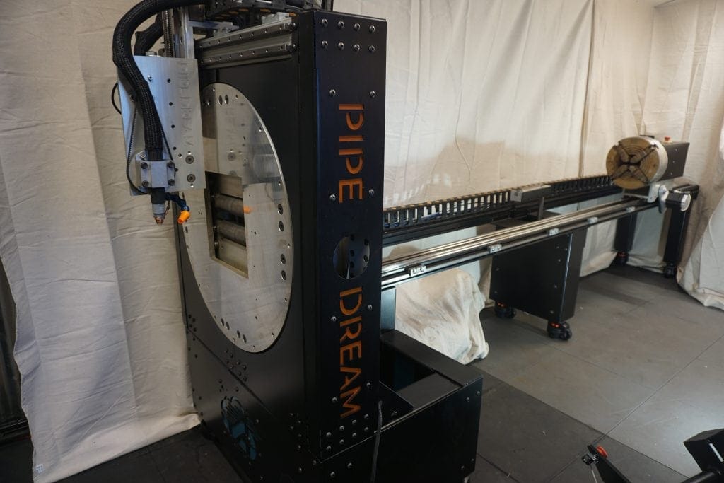 Full view of Pipe Dream CNC pipe cutting machine with automated rotary fixture and linear track system for precision tube and pipe fabrication.